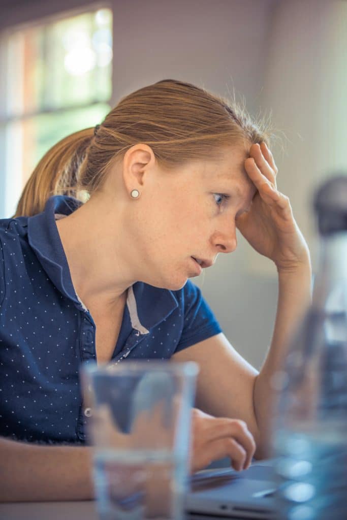 Une femme est stressée derrière un écran
