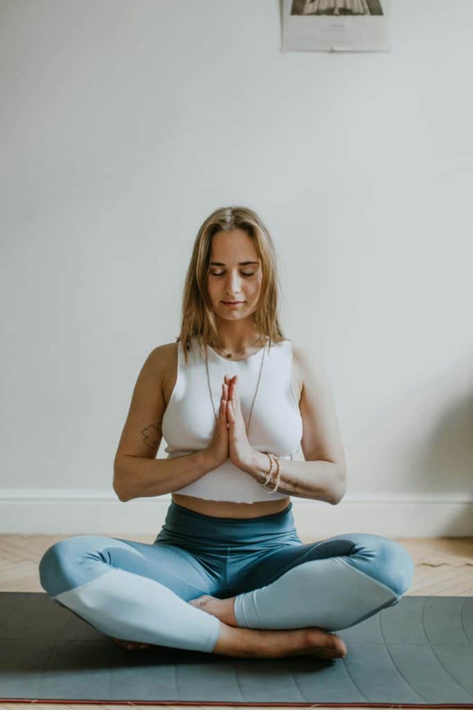 Une femme est assise en position de Lotus et médite en silence