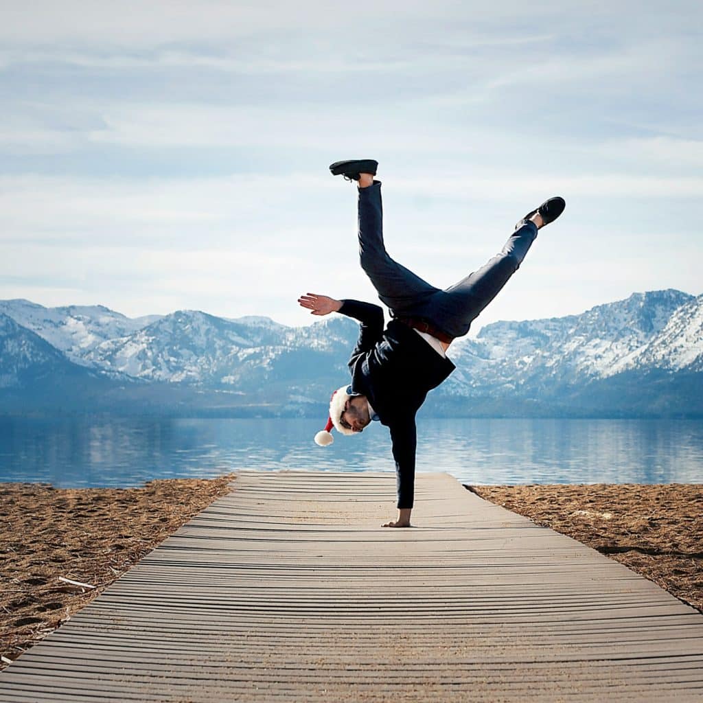 Un homme fait la roue devant un lac